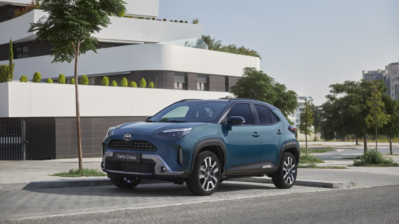 Toyota Yaris Cross zaparkowana obok białego domu